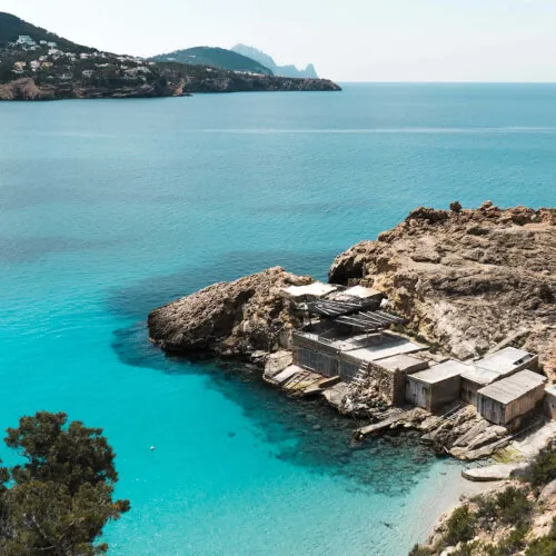 7Pines Resort Ibiza: Discover the natural wonders of Ibiza's west coast juxtaposed against a picturesque building.