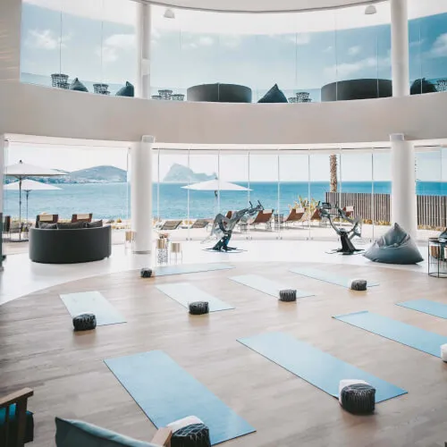 Sala de bienestar holístico con esterillas y equipo en 7Pines Resort Ibiza, un lugar para la armonía del cuerpo y alma.