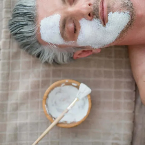 Hombre recibiendo un tratamiento facial en 7Pines Resort Ibiza para un look increíble.