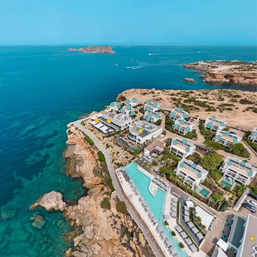 Aerial view of 7Pines Resort Ibiza, showcasing its buildings and surrounding waters
