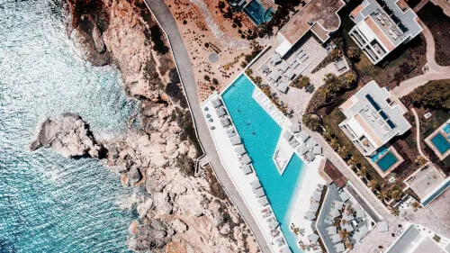 Aerial view of swimming pool next to the sea at 7Pines Resort Ibiza
