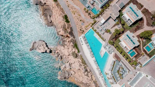 Vista aérea de 7Pines Resort Ibiza junto al Mediterráneo, santuario de experiencias extraordinarias.