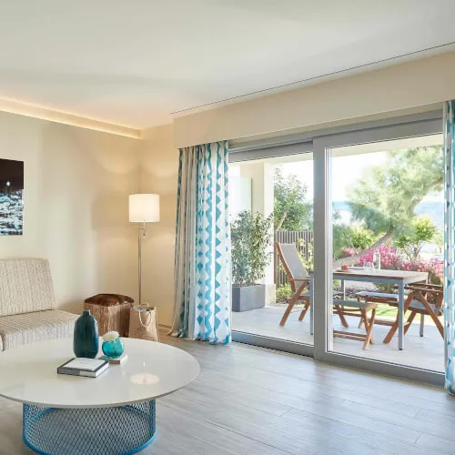 Wohnzimmer der Deluxe Garten-Poolsuite mit stilvollem Tisch im 7Pines Resort Ibiza.