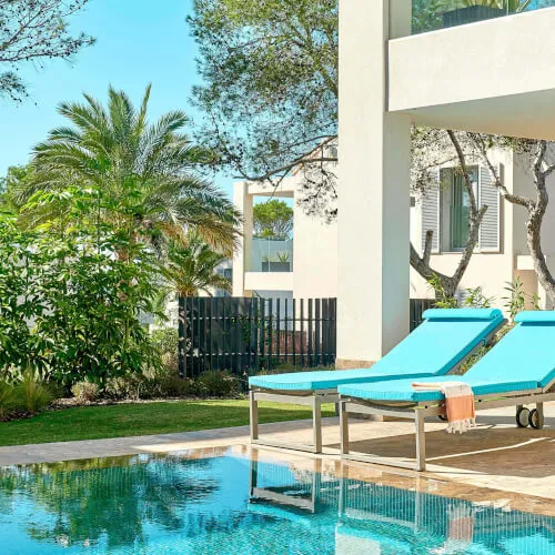 Lush garden pool bei 7Pines Resort Ibiza mit Sonnenliegen zum Entspannen