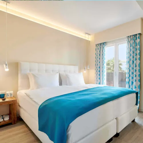 Schlafzimmer der Deluxe Garten Suite mit stilvollem Interieur im 7Pines Resort Ibiza.