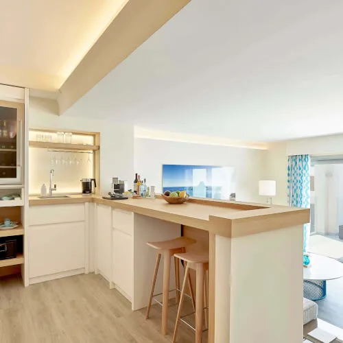 Stilvolle Küche mit Bar in der Infinity Suite des 7Pines Resort Ibiza, mit Holzboden.