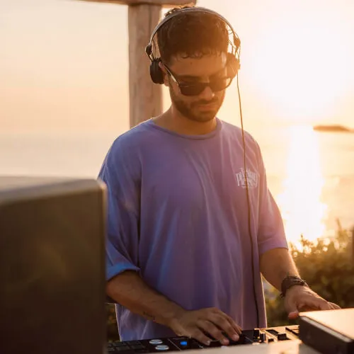 DJ playing music at sunset by the sea at 7Pines Resort Ibiza.